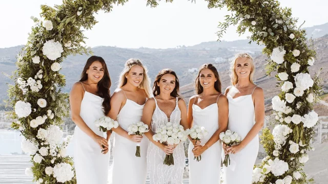 Event Planner: Charlotte Elise. Wedding on the coast, wedding view, round foliage wedding aisle, frame, white bridesmaid dresses, destination wedding.