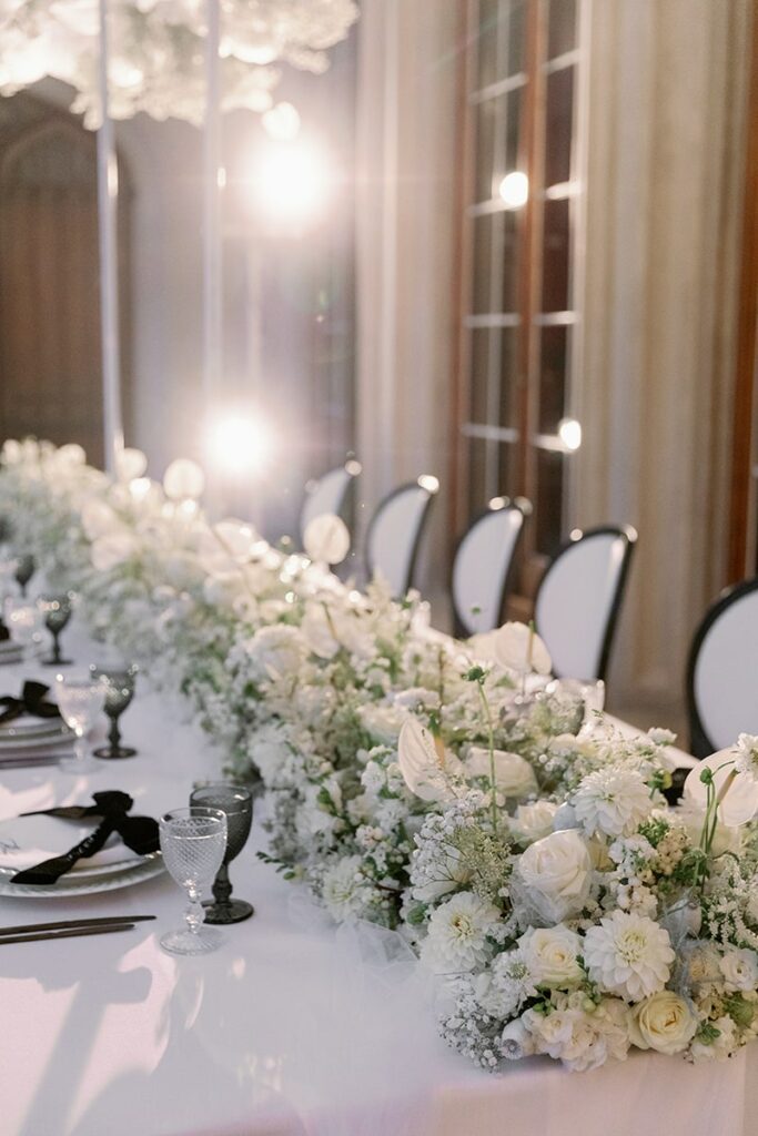 Photographer: Camilla Joy Photography. All White wedding table floral arrangement.