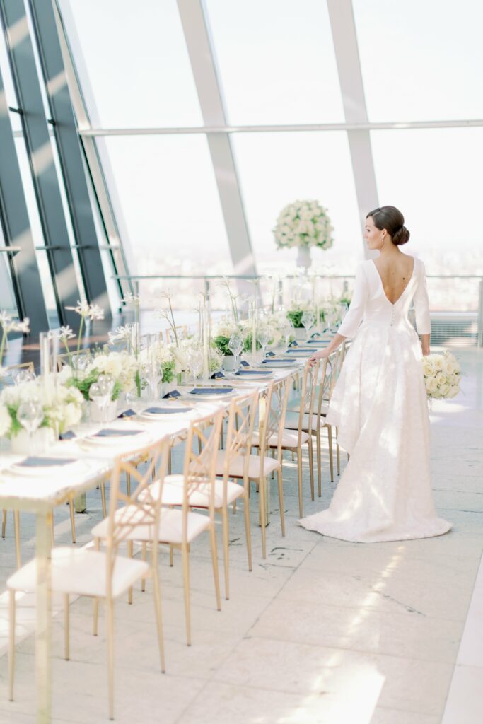 Camilla Joy Photography. Bride wearing modern open back dress. All white wedding table.