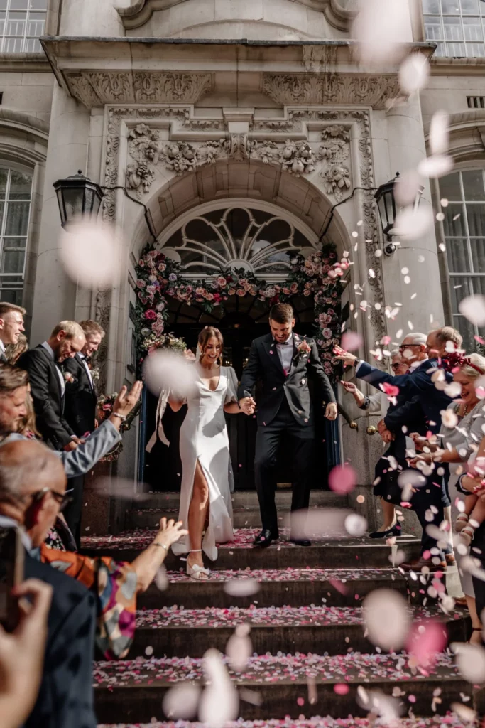 Photographer: Emma Wilder. Modern wedding couple, town hall, ceremony, pink confetti.