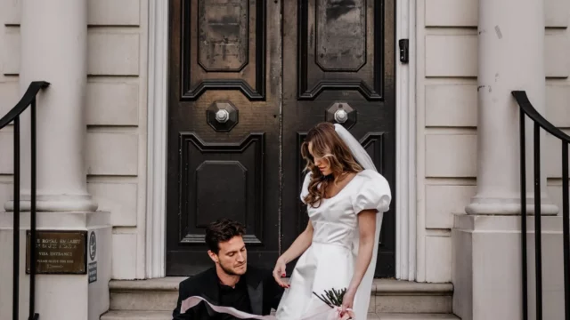 Photographer: Emma Wilder. Modern couple, short wedding dress, large shoulders, long veil. pink wedding shoes.