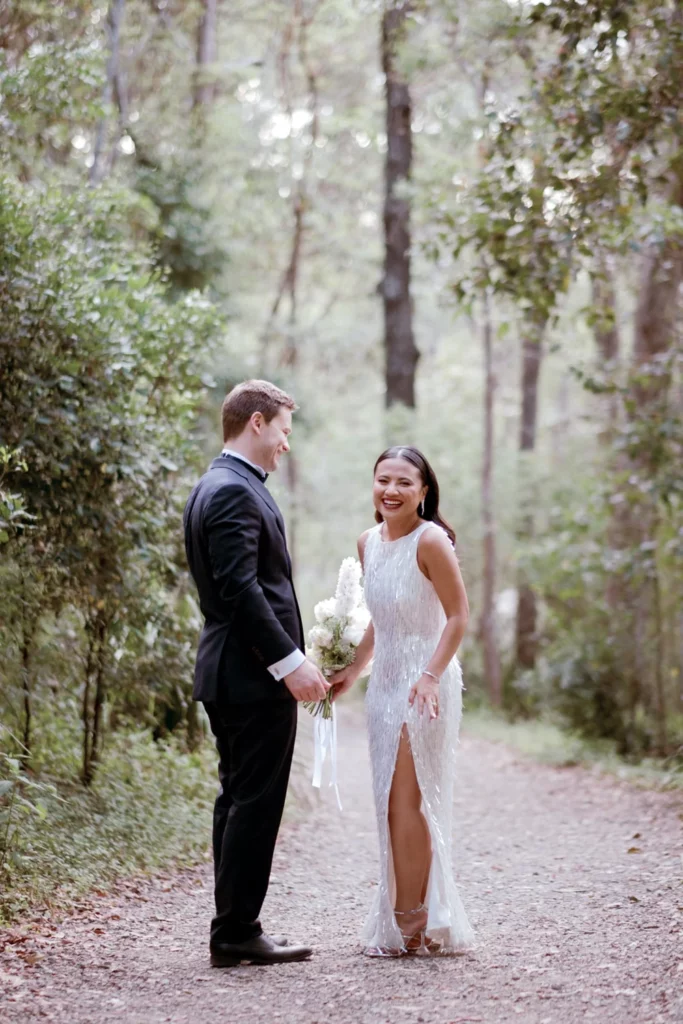 Photographer: Gavin Morgan James. Modern bride and groom, woodland wedding, modern bridal dress with leg open.