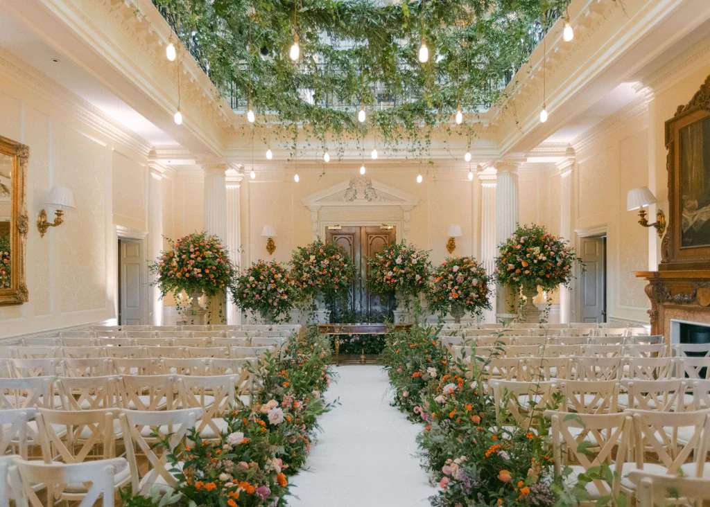 Event Planner: Hannah Hope Events. Wedding aisle, greenery ceiling, burnt orange, green dusty rose wedding flowers.