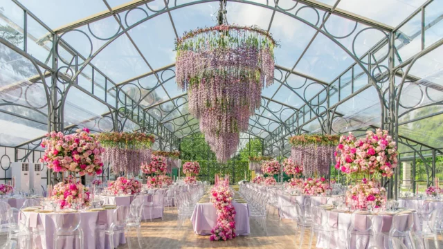 Florist: Larry Walshe. Dramatic wedding floral arrangement. ceiling flowers wedding dinner reception. pink, lilac purple wedding flowers.