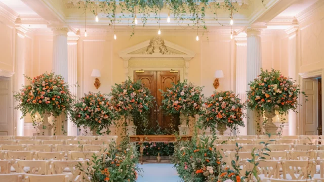 Florist: Larry Walshe. Burnt orange, wedding ceremony aisle.