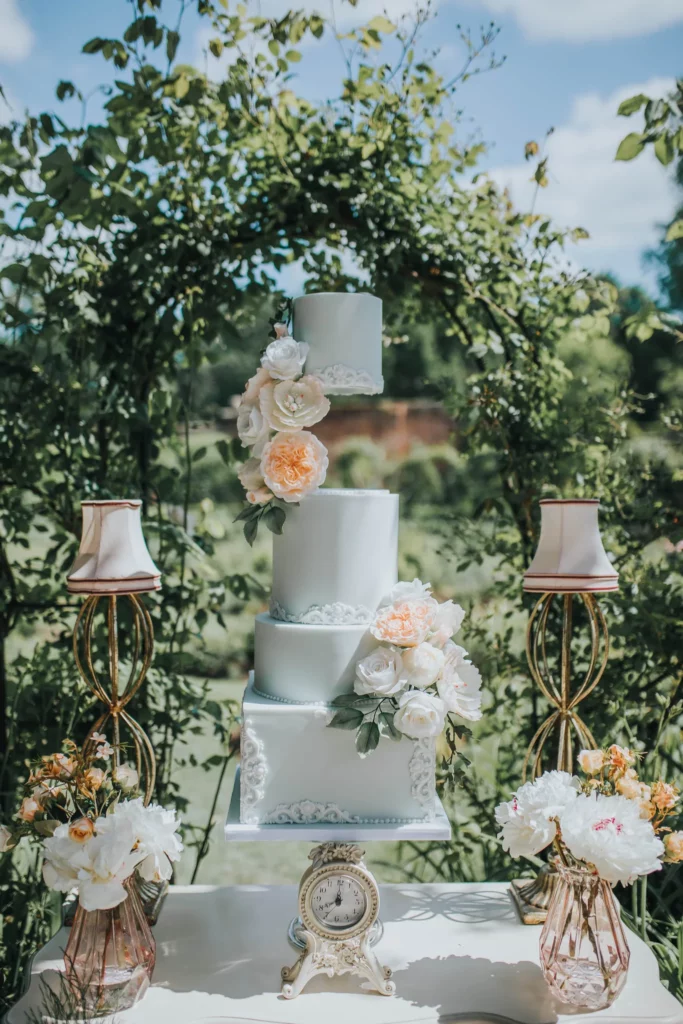 Cake Designer: RT Cakes. Pastel blue and blush orange wedding cake, 4 tiers. Alice in wonderland cake.