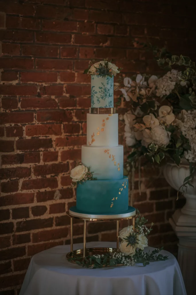 Cake Designer: RT Cakes. Blue, gold and white wedding cake 4 tiers.