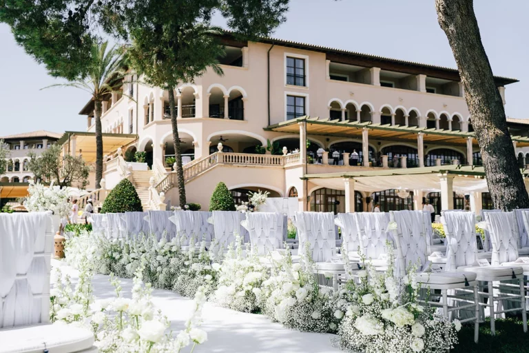 Event Planner: Tracy Lavin Events. Spain destination wedding, white wedding ceremony, white floral arrangement, chairs, wedding aisle.