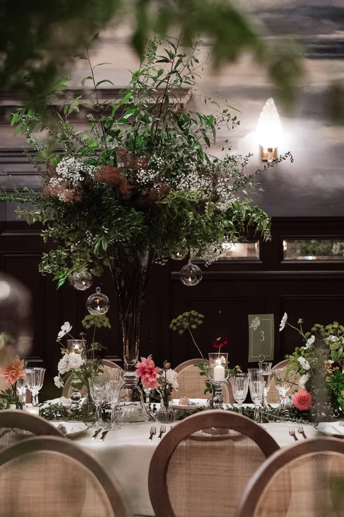 Event Planner: Emma Westacott. Dramatic wedding venue, hall, black walls, dark moody floral arrangement wedding table.